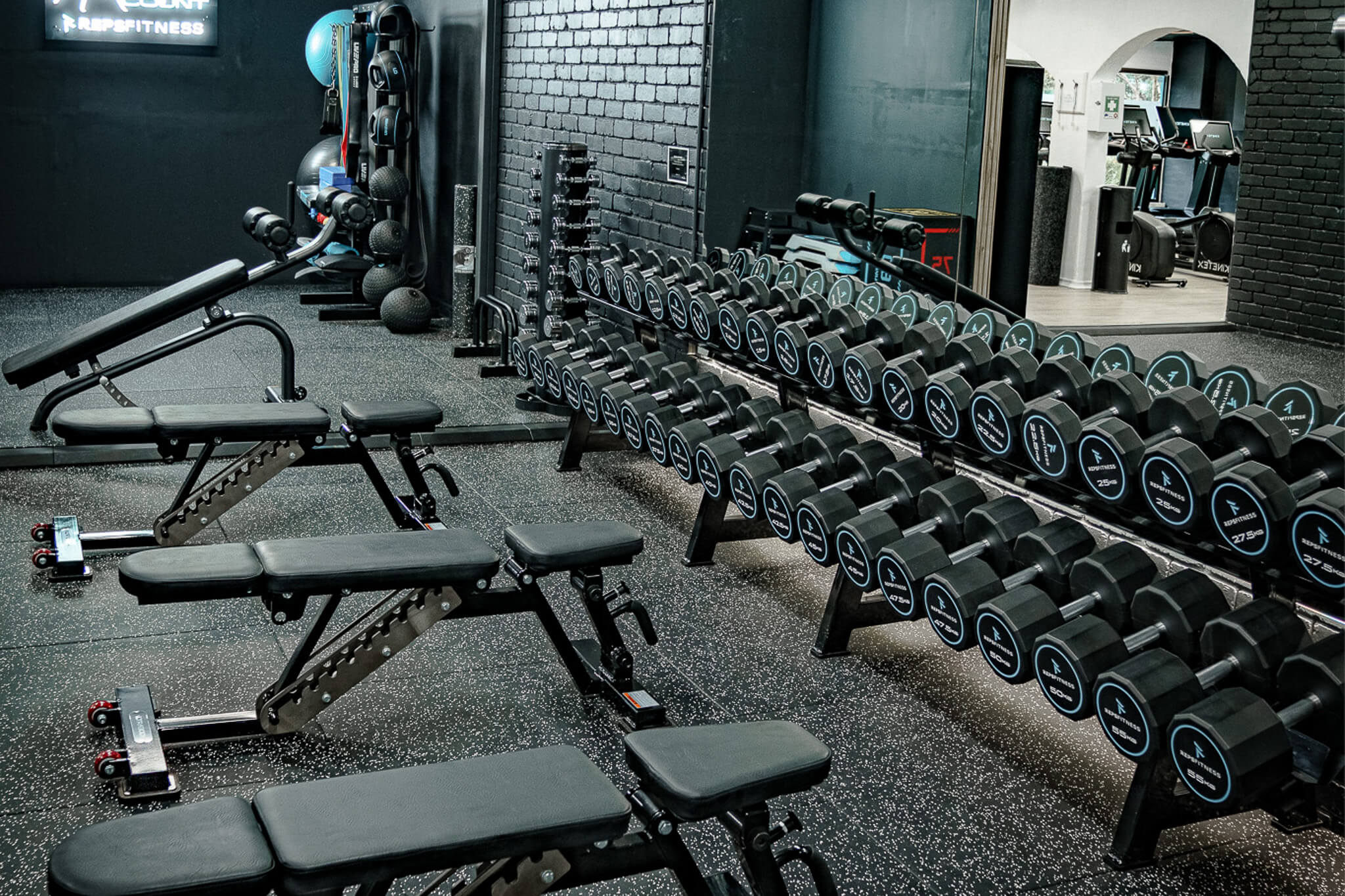 Free-weight zone at Reps Fitness with full dumbbell rack and training benches