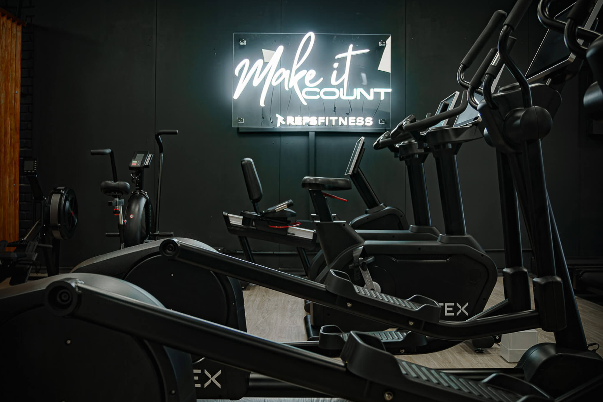 Cardio zone at Reps Fitness with treadmills and Make It Count neon sign