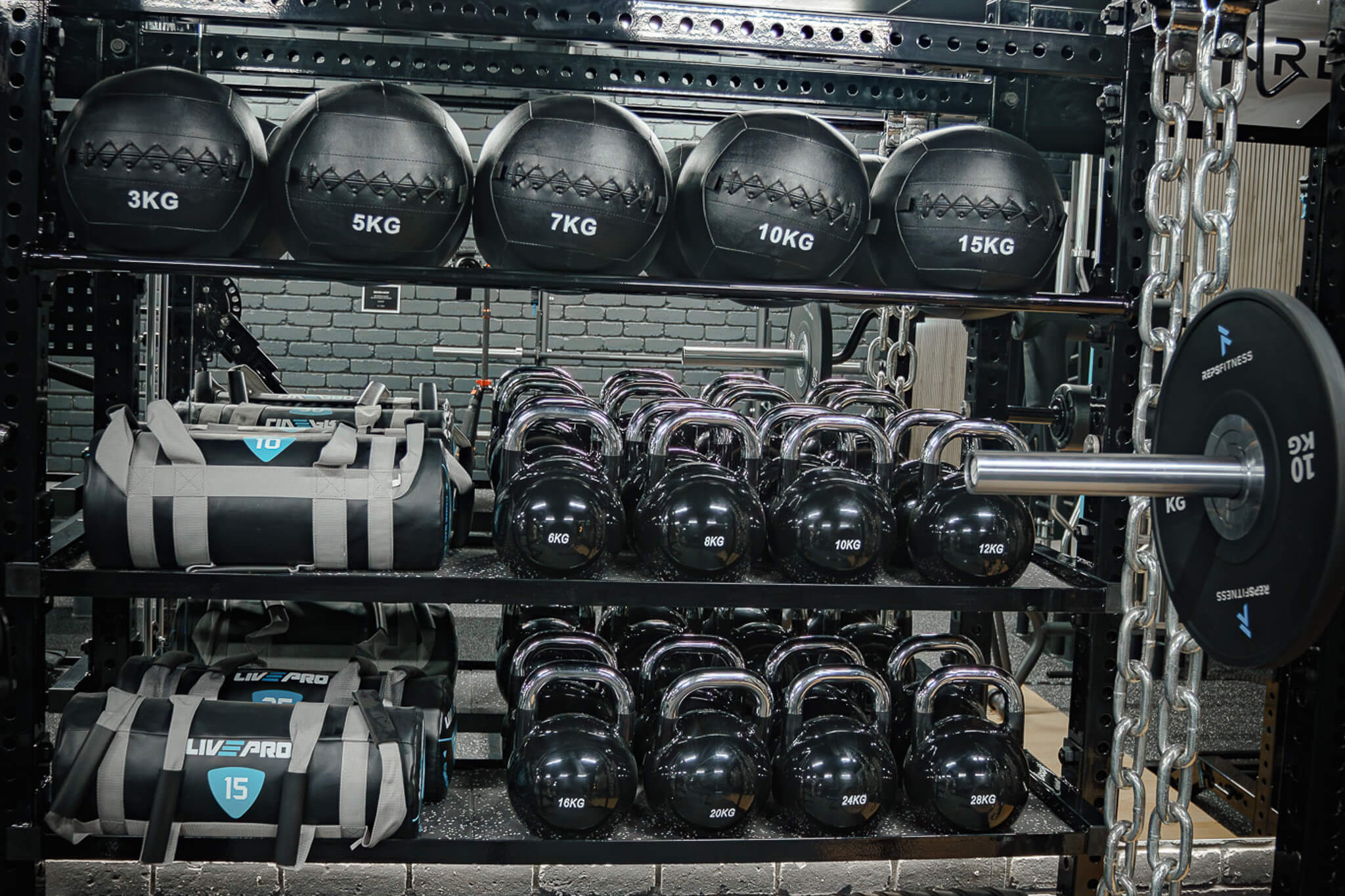 Wall-mounted medicine ball rack with weighted balls at Reps Fitness